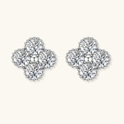 Dainty sterling silver quatrefoil stud earrings with four brilliant moissanite stones and center accent on white background.
