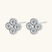Dainty sterling silver quatrefoil stud earrings with four brilliant moissanite stones and center accent on white background.