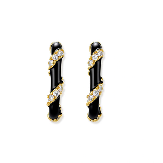 Small gold-plated hoop earrings with black enamel stripes and cubic zirconia crystals on white background.
