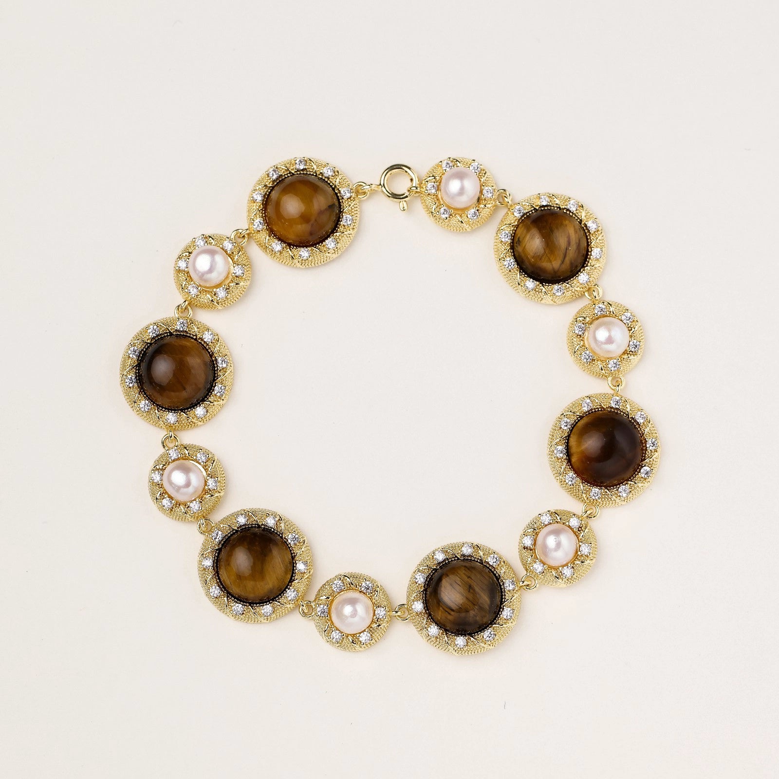 Tiger's Eye Pearl Wisdom Bracelet featuring alternating tiger's eye stones and pearls set in gold with sparkling accents, showcasing elegant luxury jewellery design.