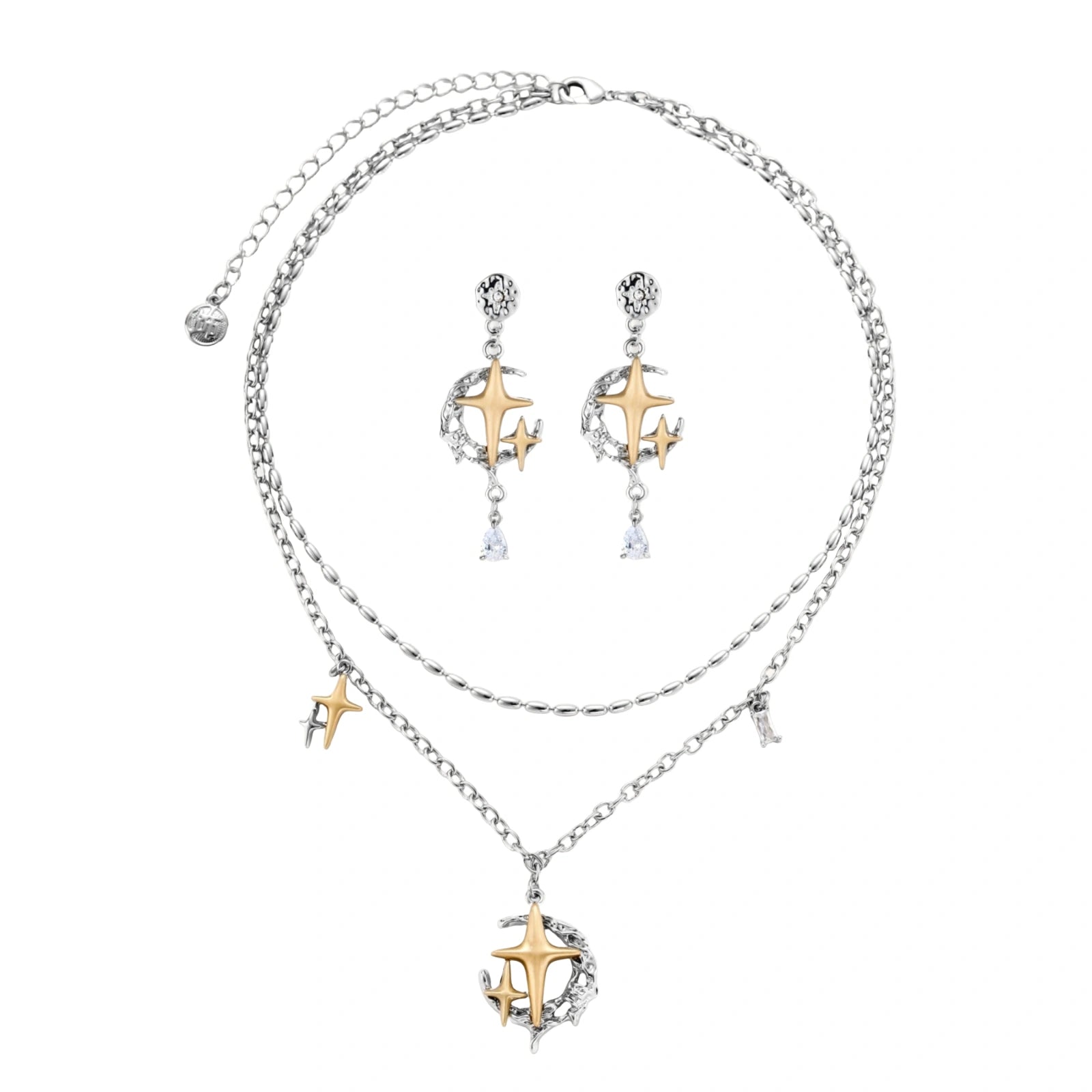 Delicate eco-brass jewelry set featuring gold star and silver moon crescents with clear zirconia crystal drops on cream background