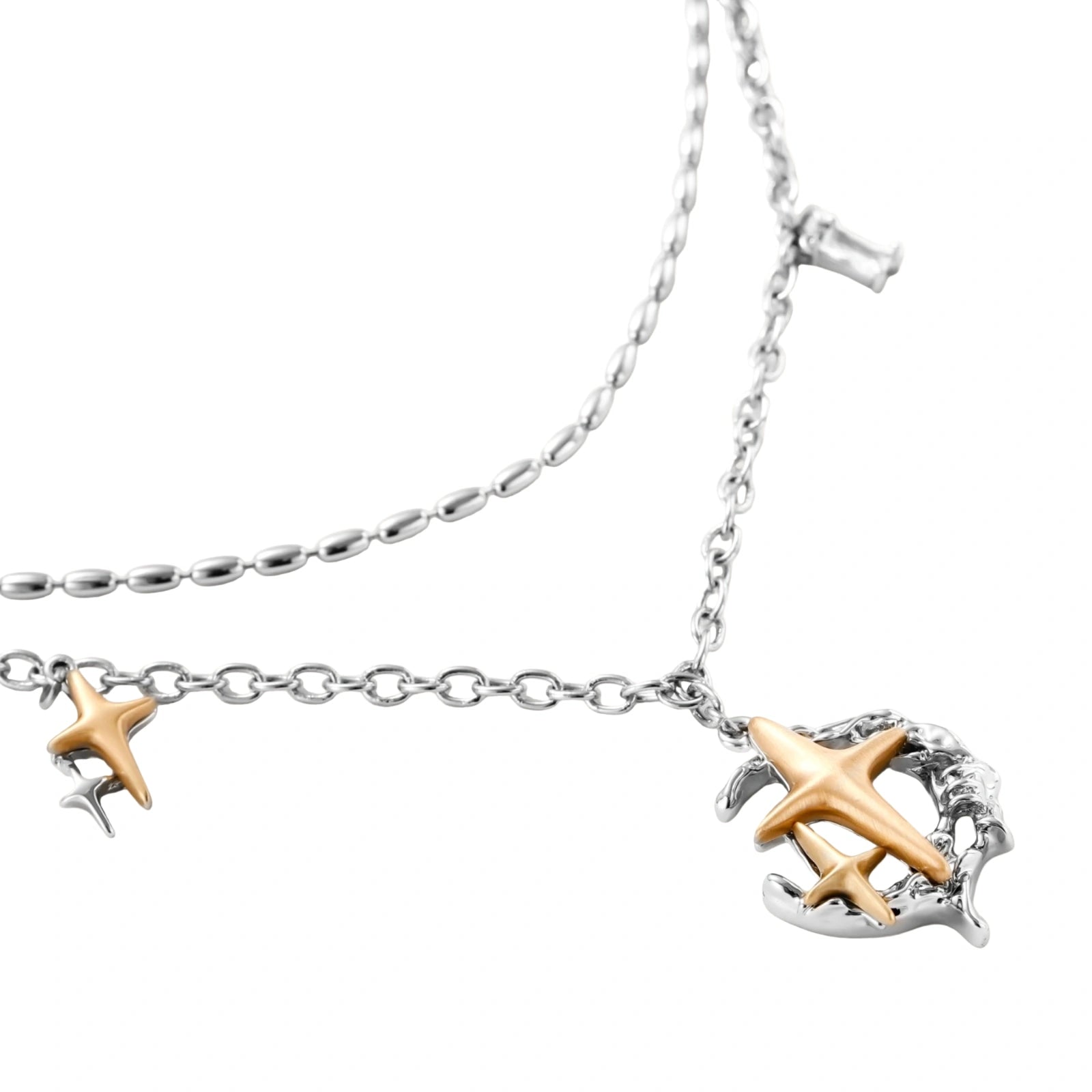 Delicate eco-brass jewelry set featuring gold star and silver moon crescents with clear zirconia crystal drops on cream background