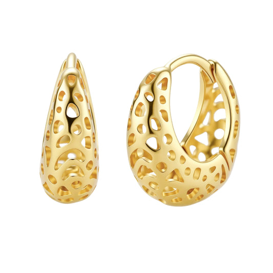 Close-up of small gold-plated hoop earrings with intricate honeycomb cutout pattern on cream background.