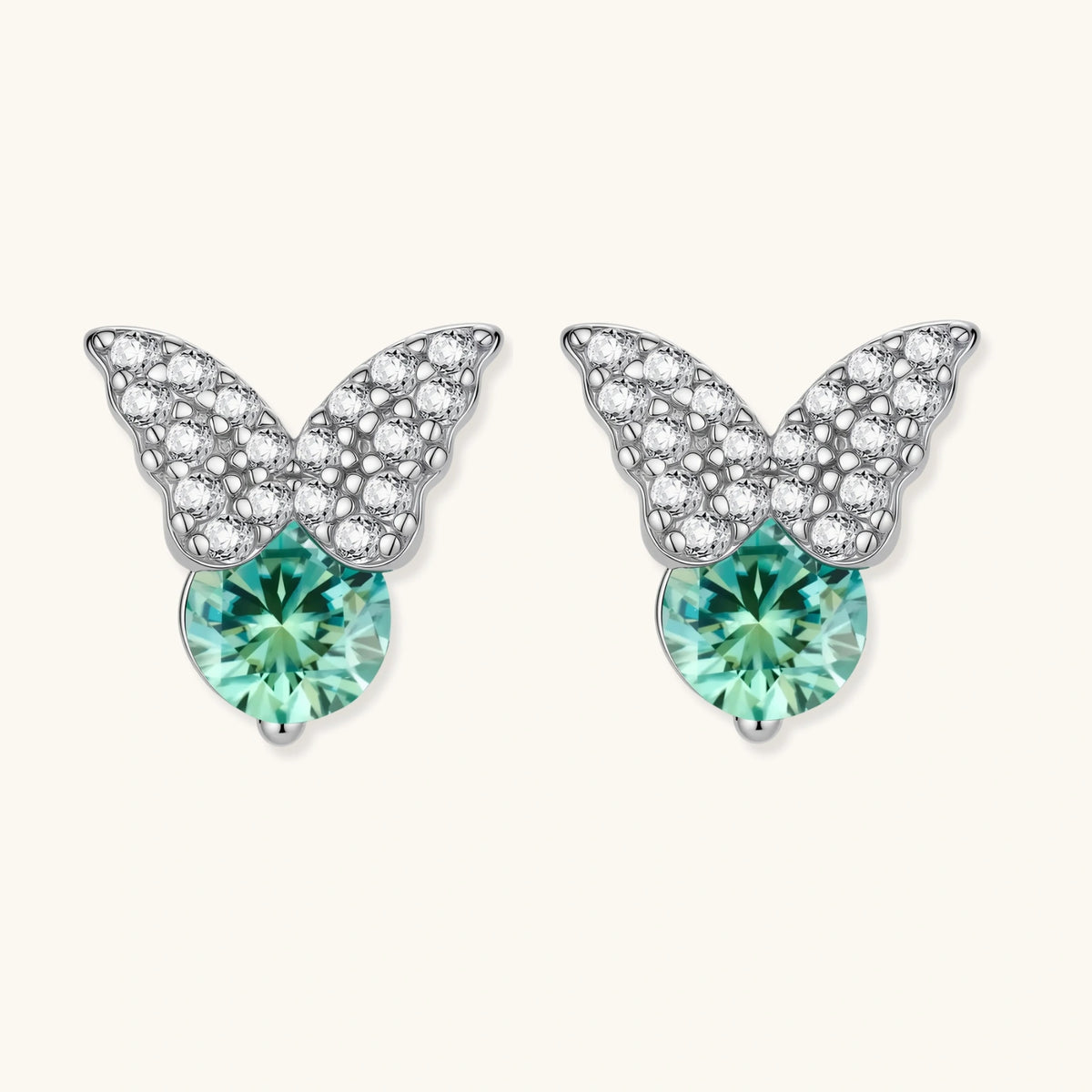 Sterling silver butterfly stud earrings with crystal wings and mint green center stones on cream background.