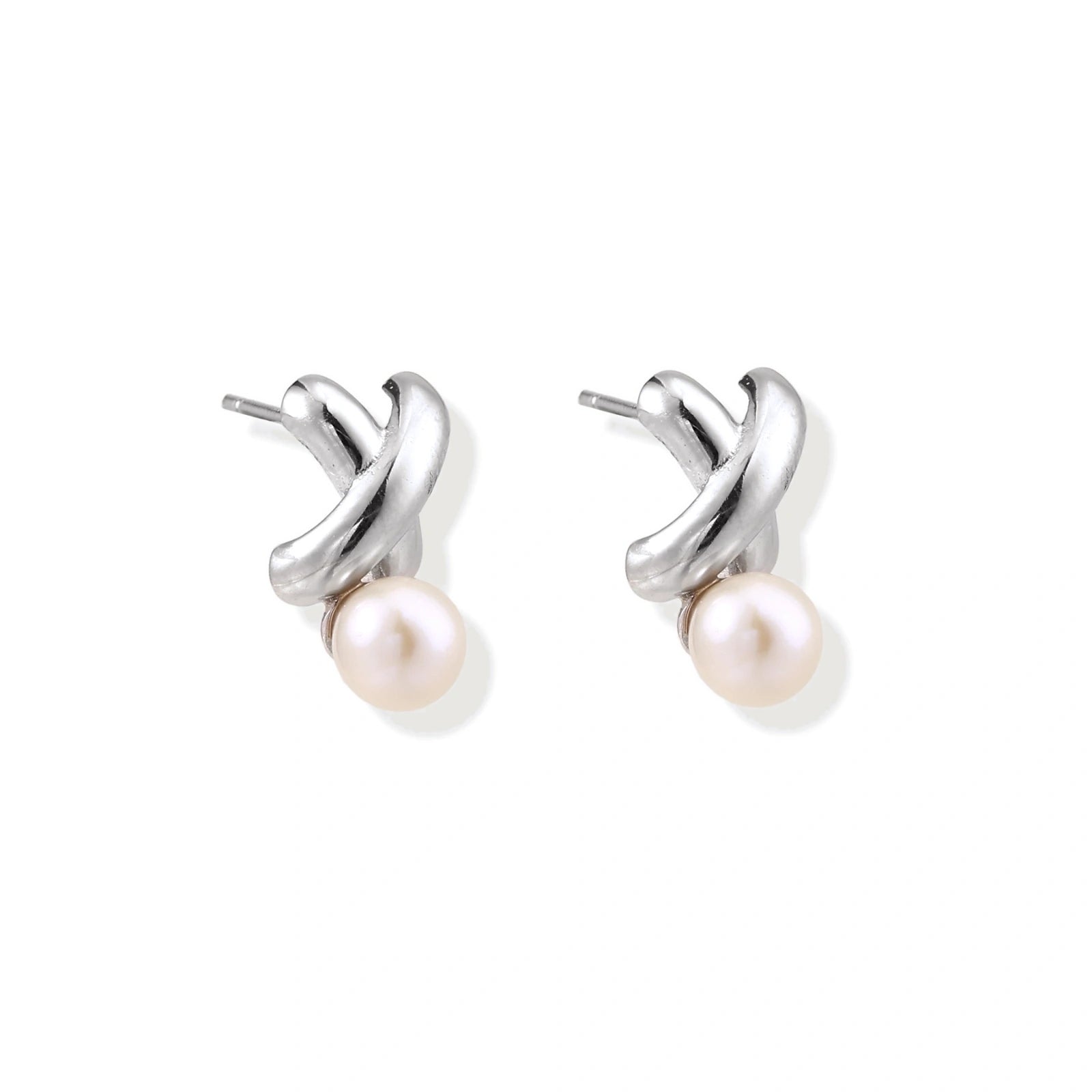 Rhodium-plated silver earrings with twisted X design and freshwater pearl drops on beige background