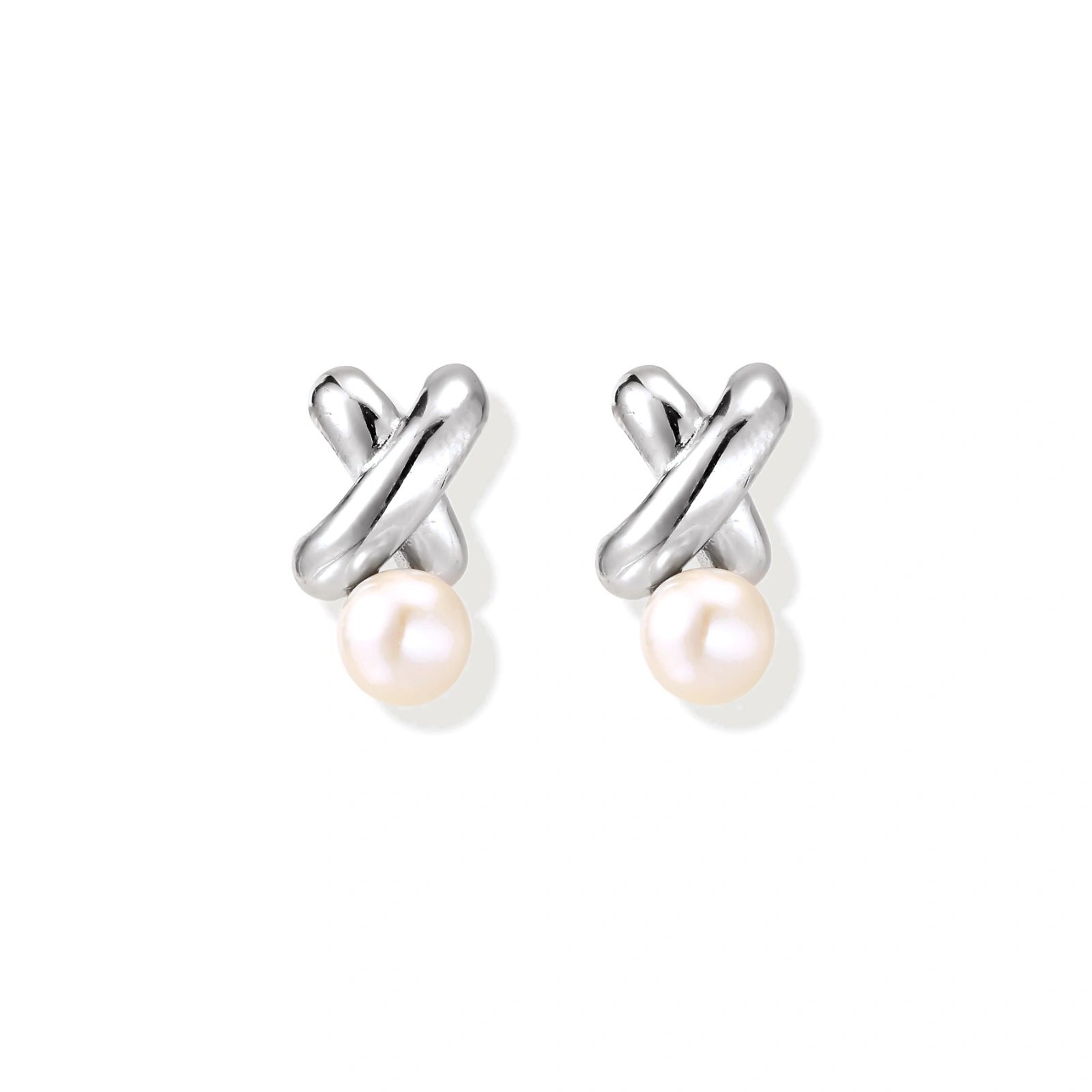 Rhodium-plated silver earrings with twisted X design and freshwater pearl drops on beige background