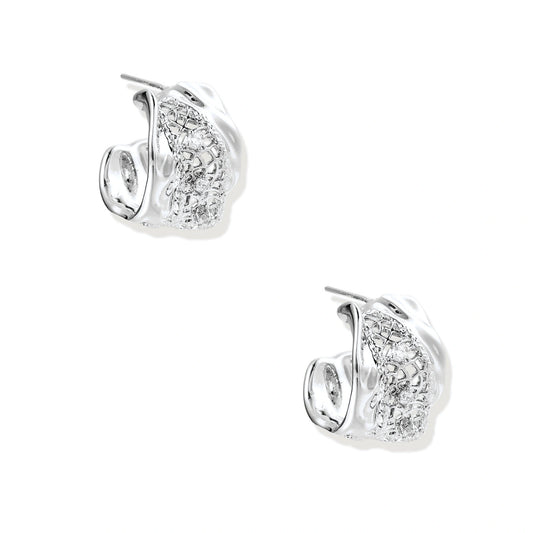 Close-up of sculptural hoop earrings with lattice center band and smooth twisted edges in white gold-plated brass with zirconia