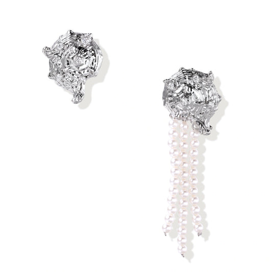 Silver-toned sculptural panther head earrings with zirconia details and white pearl drops on cream background