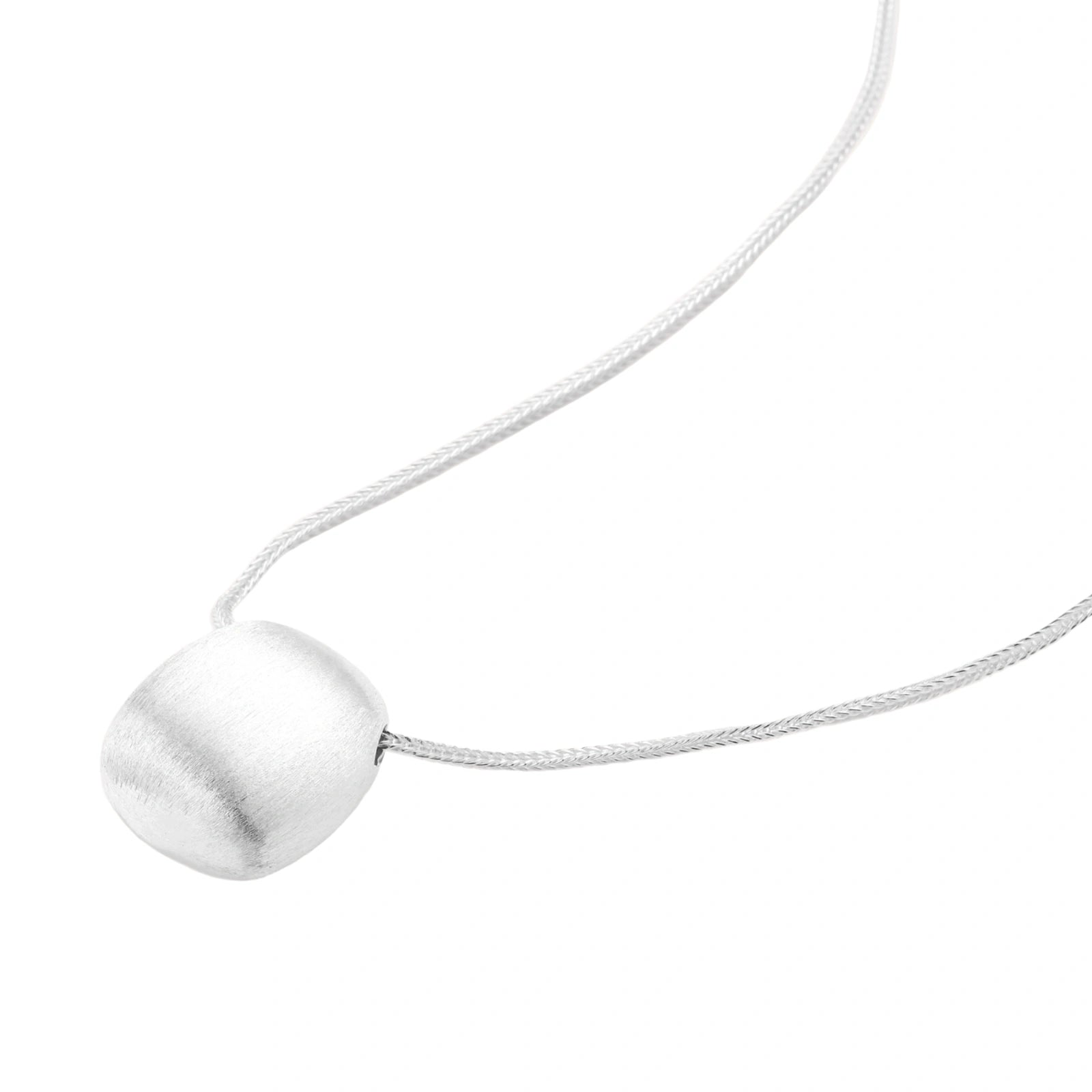 Minimalist brushed sterling silver dome pendant on delicate chain against cream background, showing matte textured finish