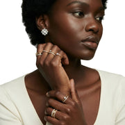 Close-up of a woman wearing elegant Pearl Studs with multiple gold plated and sterling silver rings, showcasing luxury jewellery from AlbaLuxe with ethically sourced materials.