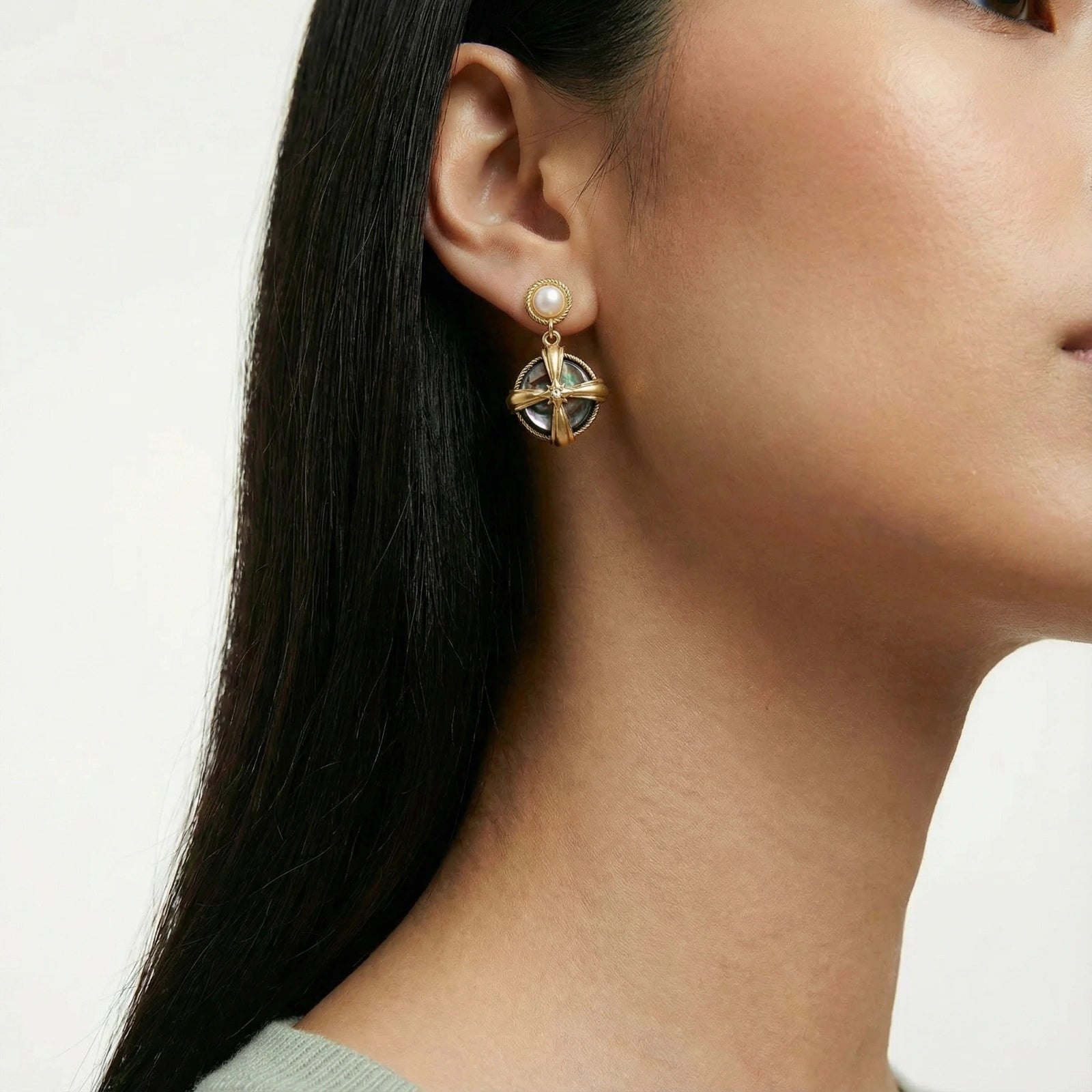 Close-up of a woman wearing Pearl Abalone Drops earrings featuring 14K gold plated accents and baroque pearl detailing, showcasing a luxury gold jewellery design.