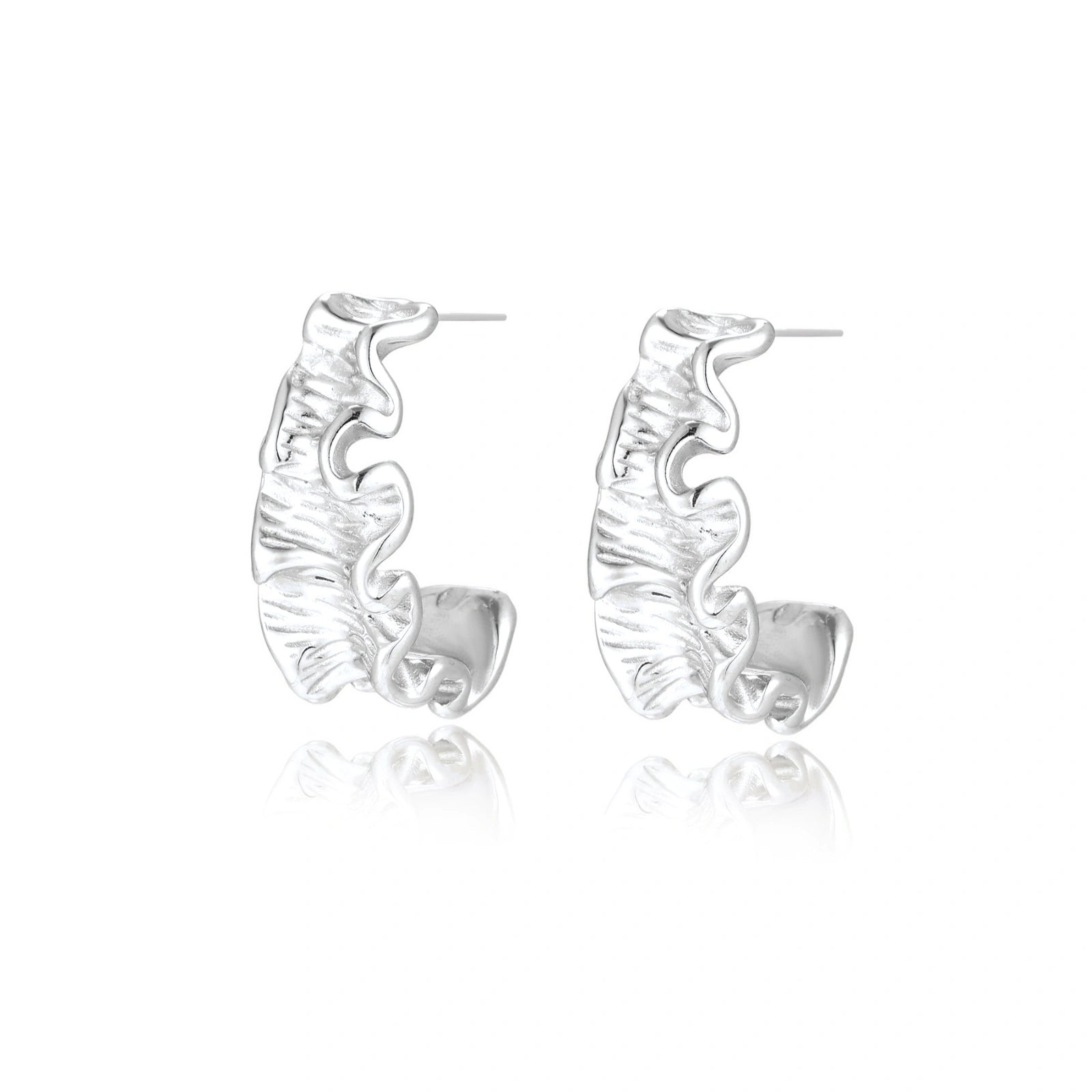 White gold plated sculptural hoop earrings with organic wavy edges and reflective metallic finish on cream background
