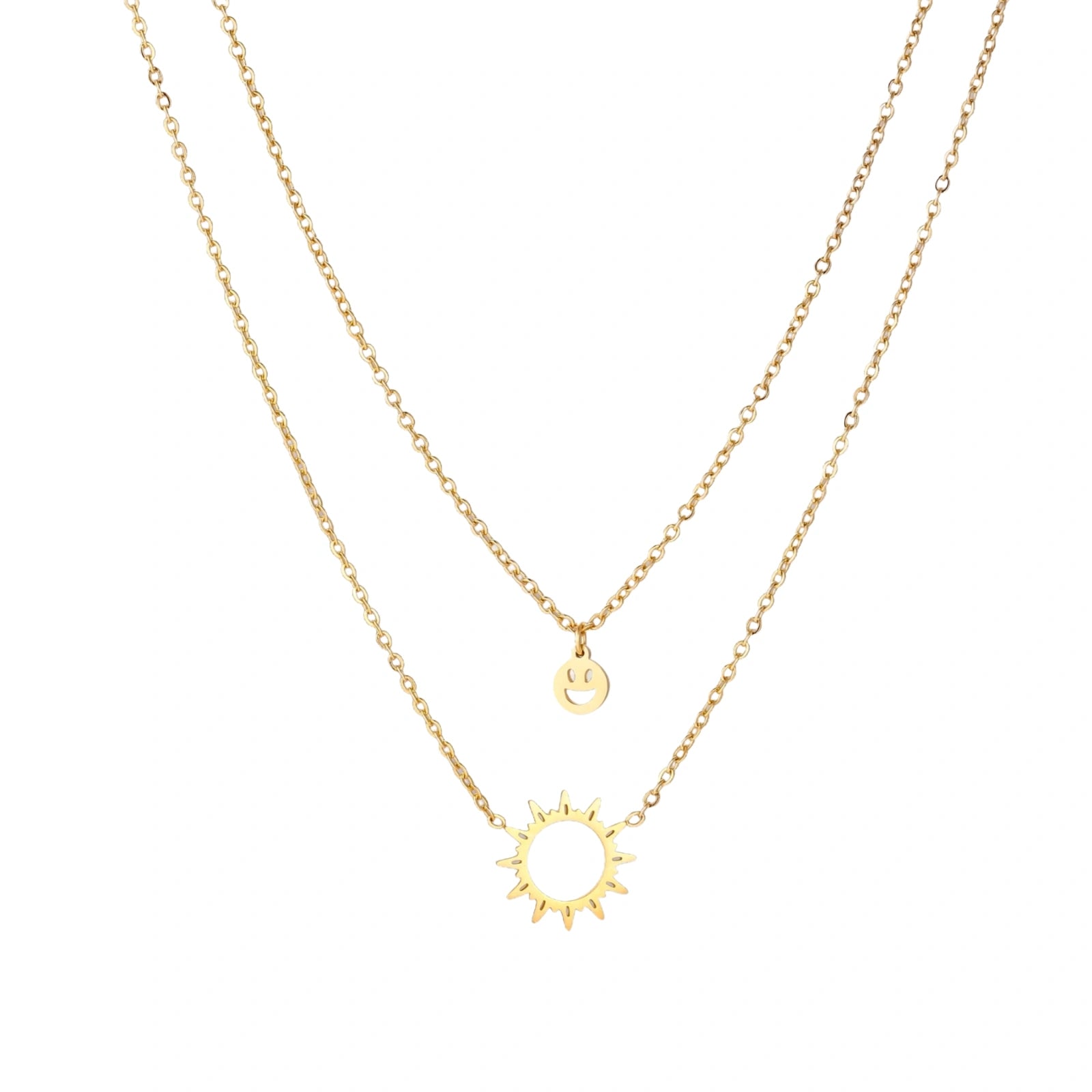 Gold layered necklace set with sunburst and smiley face pendants on delicate chains against white background.