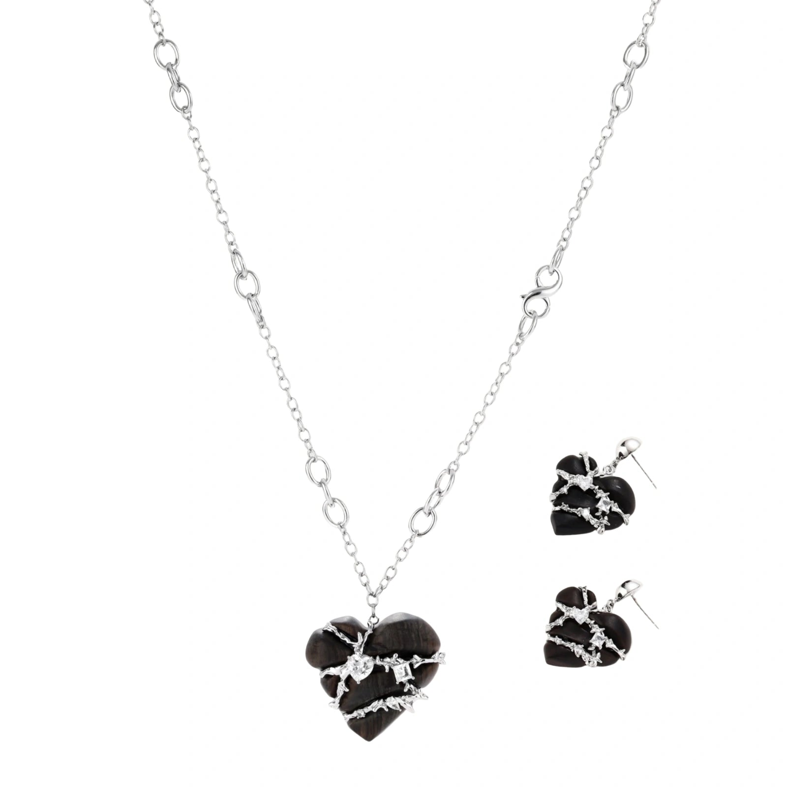 Dark ebony wood heart charms wrapped in intricate silver chains with crystal accents, shown as matching earrings and necklace set.