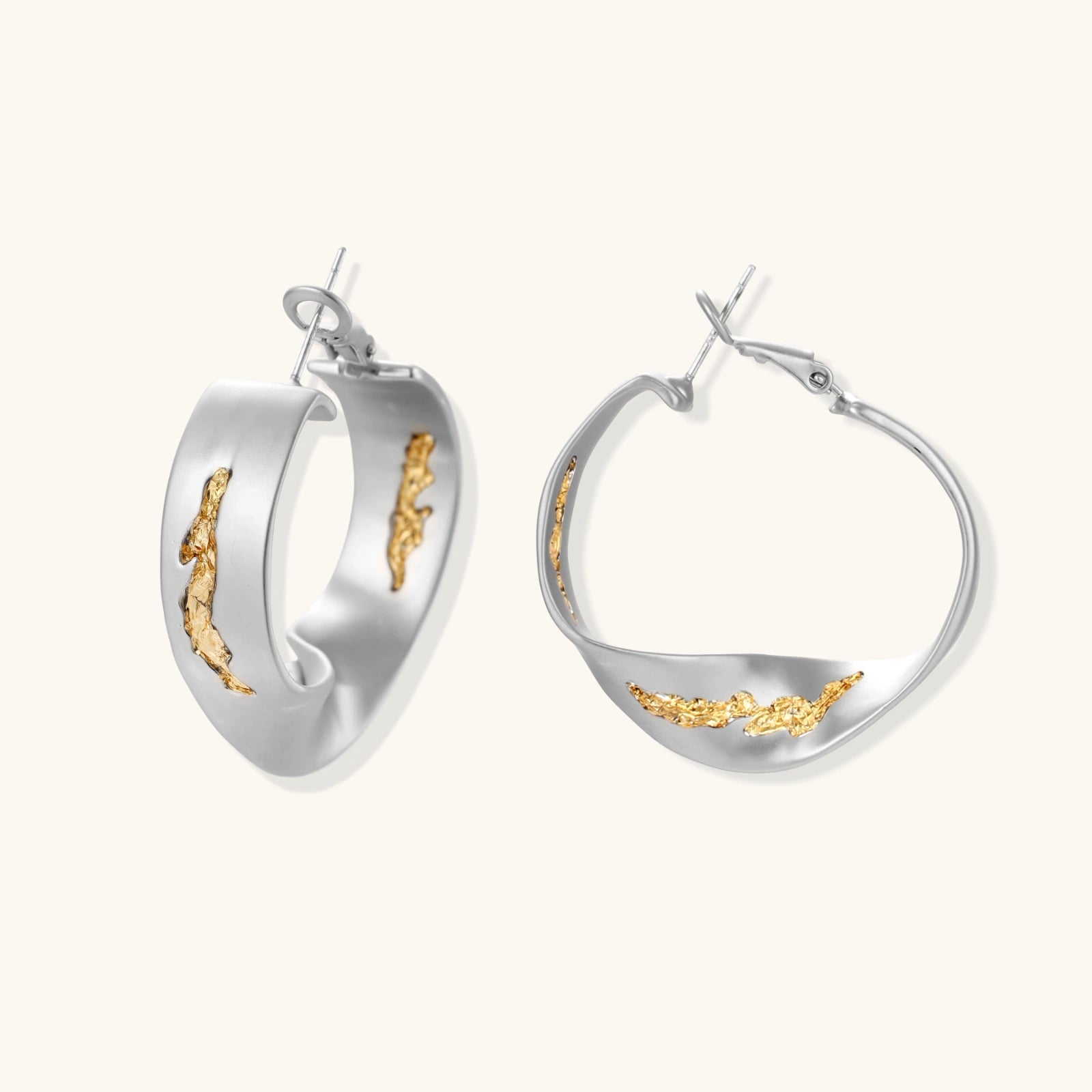 Sculptural wavy hoop earrings with crystal details and organic curved silhouette in gold and silver variants