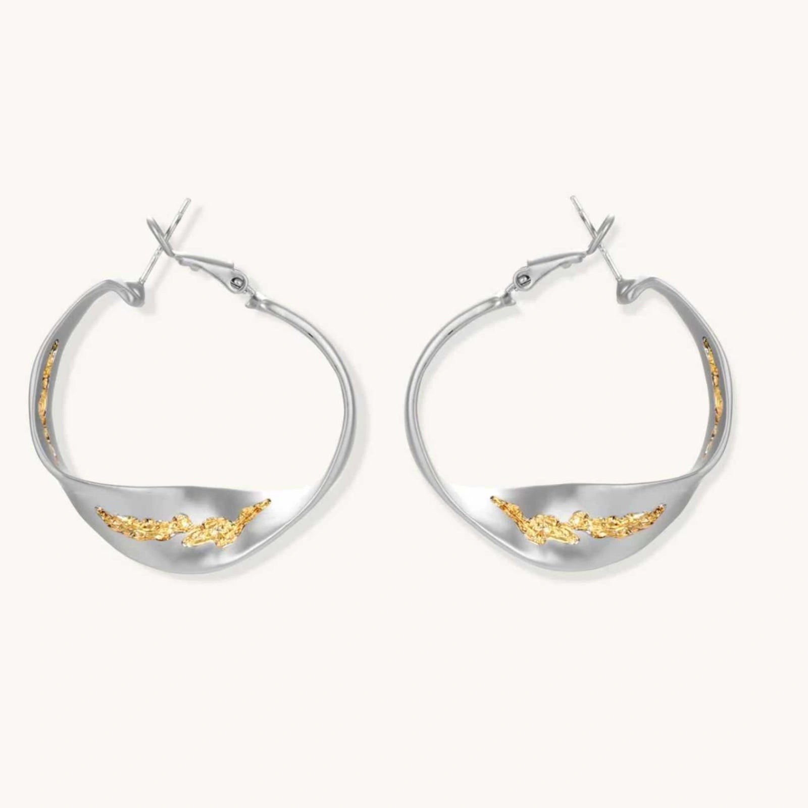 Sculptural wavy hoop earrings with crystal details and organic curved silhouette in gold and silver variants