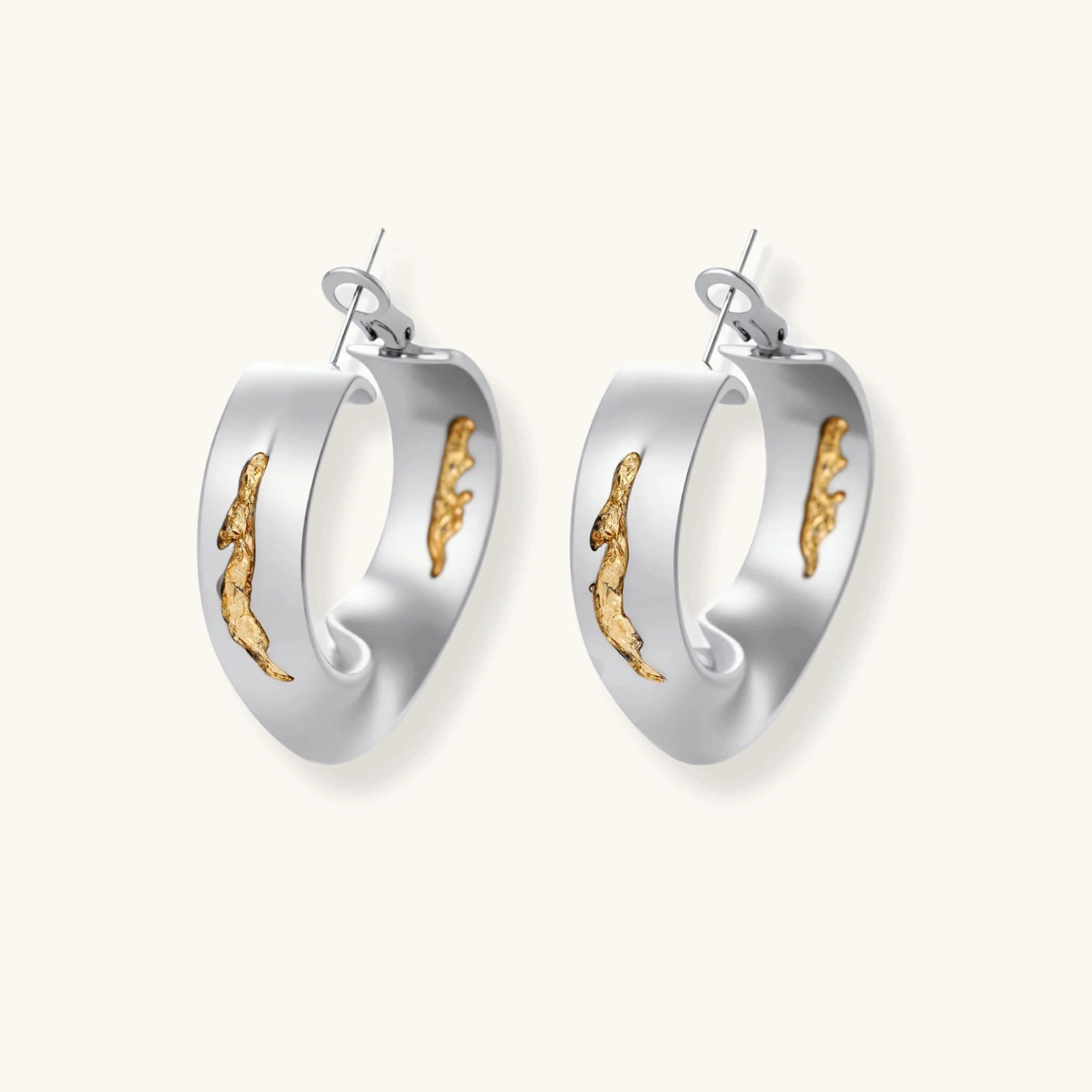 Sculptural wavy hoop earrings with crystal details and organic curved silhouette in gold and silver variants