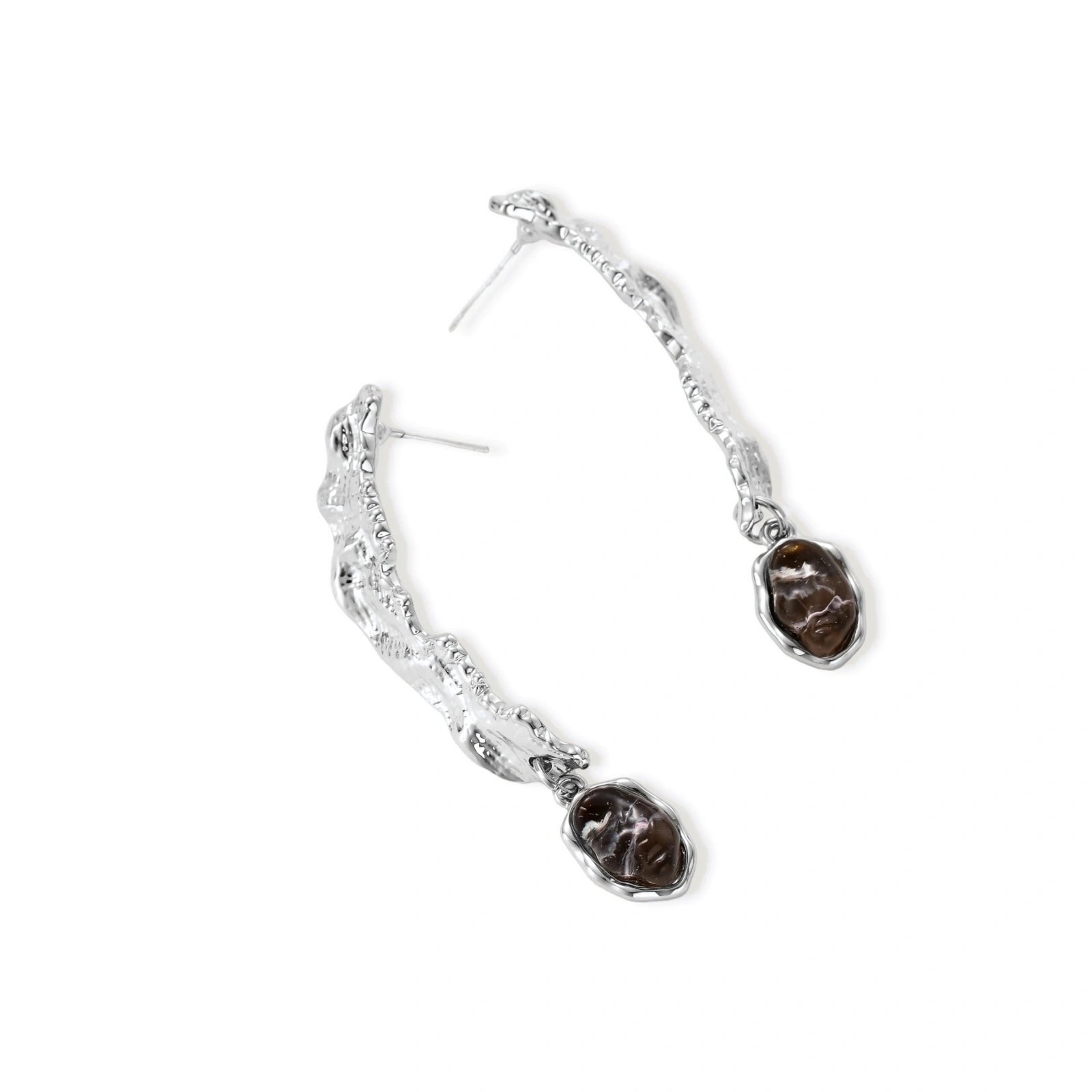 Silver-toned twisted metal earrings with dark brown oval resin stones dangling from sculptural posts on white background.