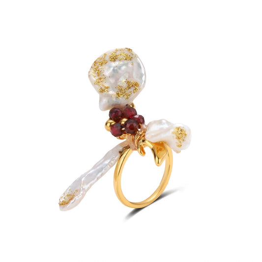 Adjustable gold-plated ring featuring clustered baroque pearls with golden inclusions and burgundy gemstones in sculptural arrangement.