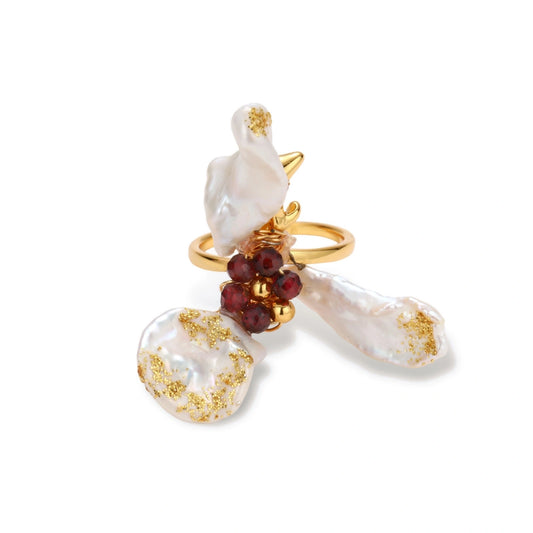 Adjustable gold-plated ring featuring clustered baroque pearls with golden inclusions and burgundy gemstones in sculptural arrangement.