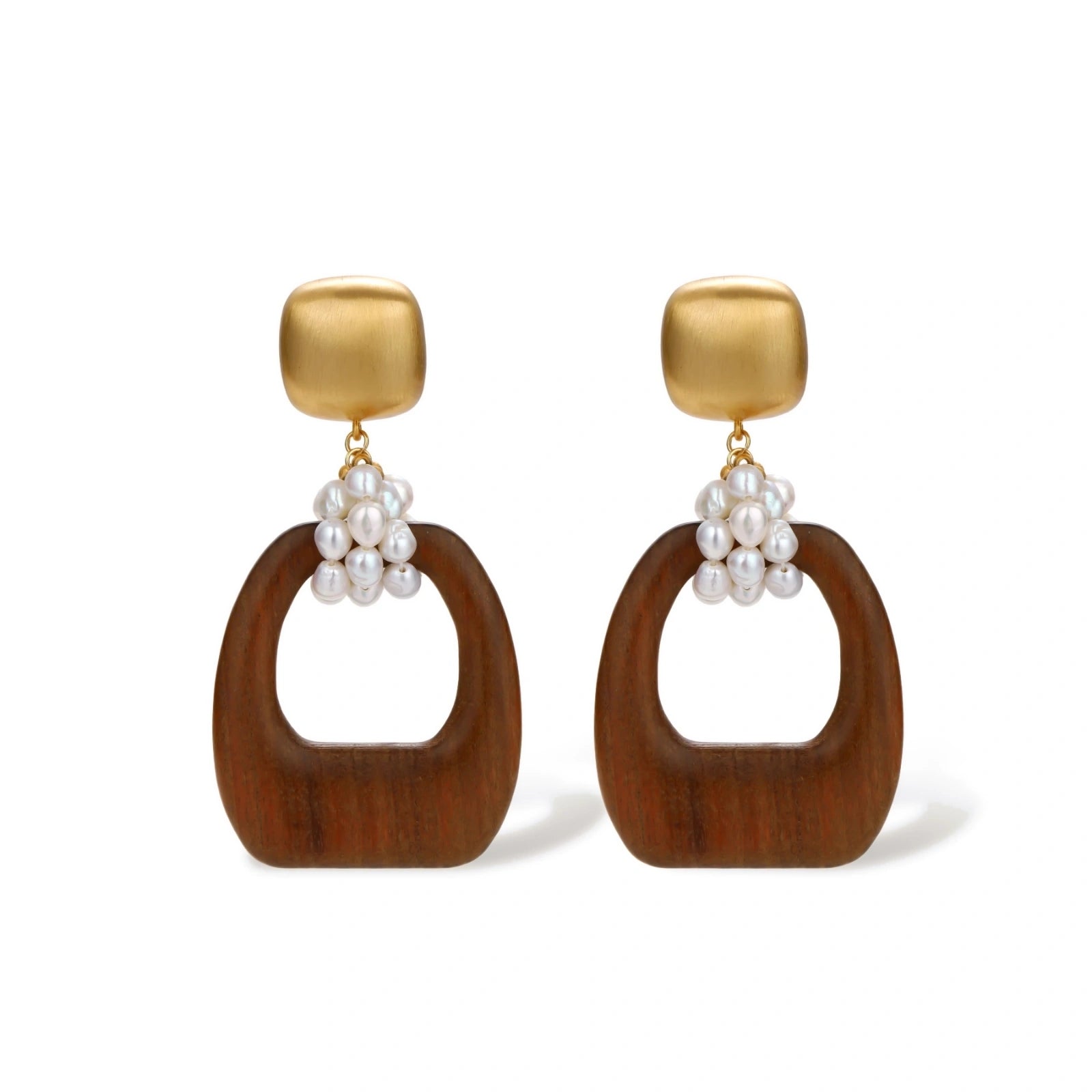 Gold-plated stud earrings with pearl clusters and organic brown wooden hoops on cream background