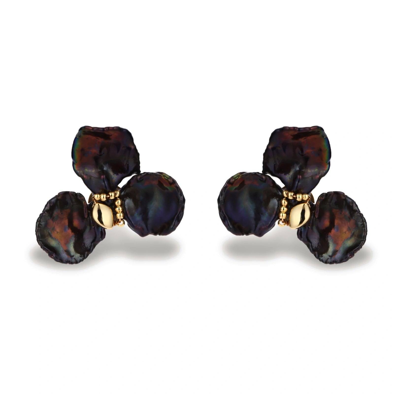 Dark iridescent baroque pearls arranged in flower pattern with 18K gold-plated center on cream background.